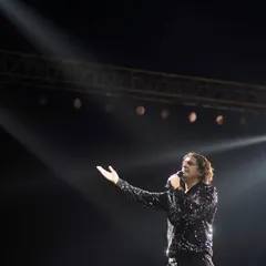 A classic shot of Sonu Nigam, the maestro, addressing the audience. The single spotlight from above creates a dramatic, almost divine effect, highlighting his legendary status.