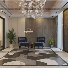 A welcoming entrance foyer designed with geometric marble flooring and plush blue armchairs. The space is anchored by a custom carved wooden door and a sculptural chandelier, creating an immediate sense of luxury.