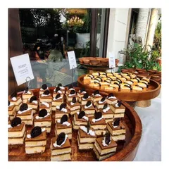A wooden platter filled with rows of delicate tiramisu or layered coffee cake squares. This classic Italian dessert is a sophisticated and crowd pleasing addition to our high tea and dessert menus.