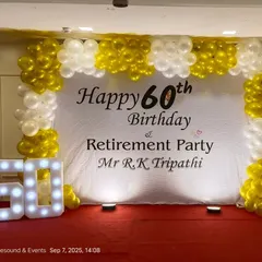 A clean and classic setup for a combined 60th birthday and retirement party. The design includes a simple white backdrop with custom text, a gold and white balloon frame, and a "60" marquee number.