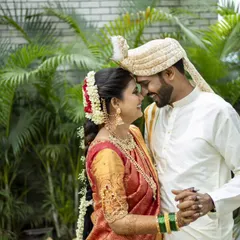 An intimate forehead-to-forehead pose against a lush green backdrop, a classic romantic portrait.