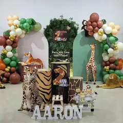 This jungle theme setup for Aaron's birthday shows how I combine balloon arches, animal cutouts, and custom name signs. I can arrange the props to create the perfect photo corner at your event.