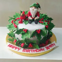 This custom Christmas birthday cake features a charming, hand-sculpted elf sitting amidst a wreath of holly leaves and berries. It’s a great example of how I can personalize a cake for your special occasion.