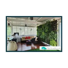 A large vertical garden serves as the stunning backdrop for this spacious covered terrace. The living wall adds a massive burst of green and improves air quality, making the seating area feel like a secluded jungle hideaway.