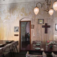 The walls in The Lovefools were hand-painted by me to achieve this perfectly imperfect, aged texture. Paired with vintage-style lighting and floral upholstery, the dining room feels like a treasured find, a place with history and heart.