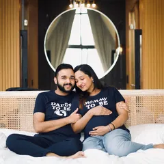 A babymoon or a cozy indoor shoot is a wonderful alternative to a traditional outdoor session. This couple chose to celebrate with matching "Mommy to be" and "Daddy to be" shirts, creating a fun and personal memory. These sessions are perfect for capturing your excitement in a comfortable, intimate setting.