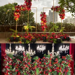 A showcase of two stunning red floral designs: a modern, deconstructed arch for an outdoor ceremony and a dense floral wall with hanging chandeliers for a reception.