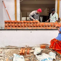 Construction is a team effort. Here, masons are meticulously laying a decorative brick wall. It's the combination of design vision and on-site skill that brings a project to life.