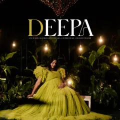 A showcase of our creative night-time maternity shoots. Here, Deepa is seated in a lush garden setting, illuminated by hanging bulbs and a heart-shaped light installation, creating a truly magical and romantic atmosphere.