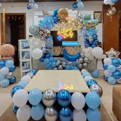 A grand 'Welcome Baby' decoration in blue and silver. This setup fills the room with a balloon arch, 'BABY' blocks, and themed foil balloons around a central table.