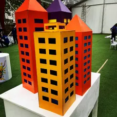 These colorful cardboard skyscrapers were created as part of a superhero city theme. They are lightweight, eco-friendly, and can be arranged to create a dynamic city skyline for an entrance or a photo booth backdrop.