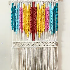 I love playing with color, and this piece shows how different vibrant cords can come together. The textured knots in bright yellow, pink, and teal create a joyful, abstract design.