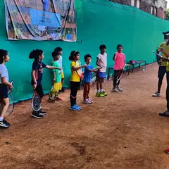 Our youngest players, some holding a racket for the first time in a tournament, listening to instructions from our coaching staff. We focus on fundamentals and sportsmanship from day one.
