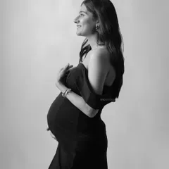 A classic black and white side-profile portrait, beautifully highlighting the silhouette of the baby bump.