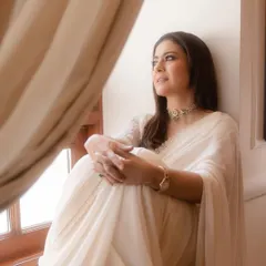 A quiet, contemplative moment by the window. The soft drape of the chiffon saree and the elegant styling create a look that is both sophisticated and deeply personal.