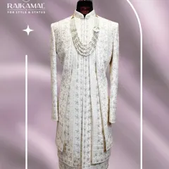 This is the same magnificent ivory sherwani, shown here with a different styling option. The layered silhouette and intricate detailing are designed to create a truly royal presence.