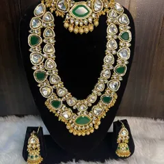 Our popular green and white Kundan bridal set, displayed to show all its components. This rental includes a choker, a two-layer long necklace, a pair of jhumka earrings, and a maang tikka. It's a complete and affordable solution for your wedding jewellery.