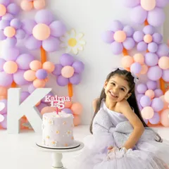 A huge smile for the birthday girl. This shot captures the pure, simple happiness of celebrating a milestone with a special cake and a fun outfit.