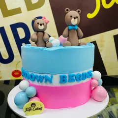 A 2kg gender reveal cake with a pink and blue split design and two teddy bears.