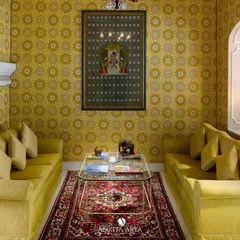 A sitting room at the Nivah heritage property, featuring my Mughal-inspired jaali wallpaper in a vibrant yellow. The design adds warmth and historical context, making the space feel both luxurious and authentic.