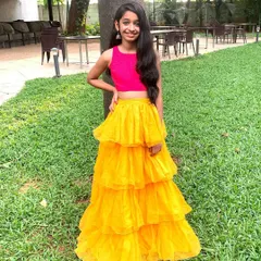 This outfit brings together a bright pink crop top and a sunny yellow tiered net skirt for a look that is pure fun. It’s a perfect example of my Indo-Western designs, combining bold colors and playful textures for a standout party look.