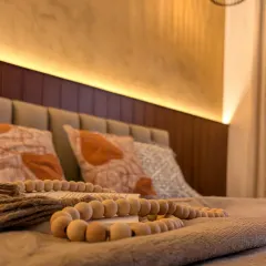 We focus on textures to create warmth, as seen here with the wooden beads, soft throws, and the upholstered headboard.