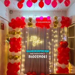 A focused look at the balloon arch and fairy light curtain from a romantic room decoration. The combination of red, white, and gold balloons creates a classic and festive atmosphere.