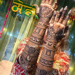 A stunning full-arm bridal mehndi for a client's big day. The design incorporates peacock motifs and personalized initials.