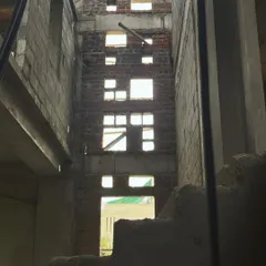 An identical view of the internal courtyard, emphasizing the verticality of the space and the pattern of fenestrations on the exposed brick wall.