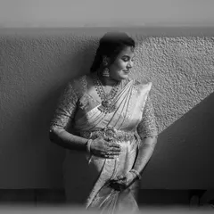 A timeless black and white maternity portrait. The strong diagonal line from the shadow adds a powerful graphic element, while her expression is one of serene anticipation.