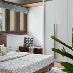 A bedroom from the 'Pepper and Coffee' project, featuring a custom wooden bed, a cozy window seat, and a clean, minimalist aesthetic.