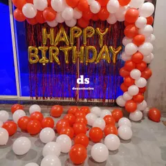 A bold and classic red and white balloon arch over a red shimmer curtain. The 'Happy Birthday' foil balloons in gold add a touch of contrast and celebration.