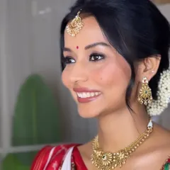A happy bride is the most beautiful bride. Here, her hair is styled in a neat, traditional bun with a fresh gajra, allowing her beautiful smile and stunning jewelry to shine.