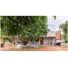 At the 'Aamra' farmhouse, life unfolds around a mature mango tree, which serves as the heart of the home. The design prioritizes the existing landscape, creating a built form that respects and integrates with the natural environment, offering spaces for quiet contemplation and family life.