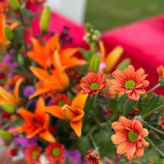 The bright, cheerful colors of orange lilies and chrysanthemums. Using fresh, high-quality flowers is essential for creating decor that feels alive and luxurious.