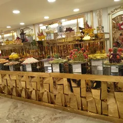 Another angle of the magnificent golden buffet counter, highlighting the elaborate food presentation. Each dish is placed on elevated stands to create a visually impressive feast for a grand celebration.