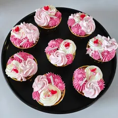 An overhead view of a batch of my vanilla and strawberry buttercream cupcakes, ready for a celebration. Each one is handcrafted and decorated with care.