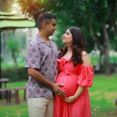 A tender moment between a couple, surrounded by the lush greenery of the park. The soft light and their loving gaze make this a truly romantic maternity shot.