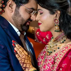 A close-up, intimate portrait showing the couple's deep connection. The focus is on the bride's intricate mehndi and the couple's gentle embrace.