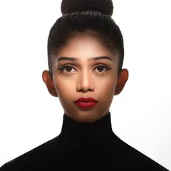 A powerful, clean headshot is essential for any model's portfolio. This image showcases a classic, high-fashion look with a tight bun, sharp cat-eye liner, and bold red lips. The high-key lighting ensures the focus remains entirely on the model's strong features and direct gaze.