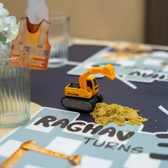 It's all in the details: a tiny construction vest drink charm and a miniature excavator with edible "dirt" on a personalized placemat.