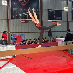 A gymnast performs an acrobatic element on the balance beam during the Gurgaon NCR Inter-Academy Competition. Maintaining balance during dynamic movements is a key skill we teach.
