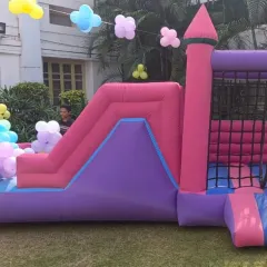 This pink and purple bouncy castle with a slide is perfect for a princess or fairytale-themed party. It provides a safe and fun structure for kids to jump and slide on.
