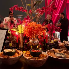 The ambiance of an evening celebration, where warm lighting and rich floral arrangements complement our bountiful displays of fresh dips and artisanal breads. Every element is designed to create a cohesive and luxurious experience.
