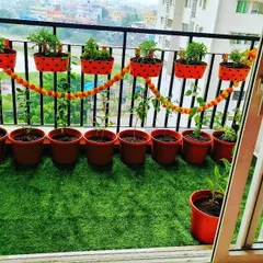 We love adding a festive touch to our gardens. For this balcony, we used vibrant red pots for both the floor and railings, and even added a traditional marigold garland to create a cheerful and welcoming atmosphere.