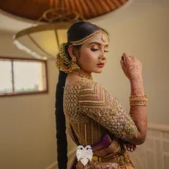 A stunning shot of Priya, her gold blouse and intricate hairstyle creating a look of timeless elegance.