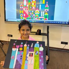 A proud student from our summer art camp displays her colorful castle painting, inspired by the artist Mary Blair. Our classes often explore art history in a fun and accessible way.