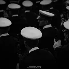 A different perspective on the parade. This high-angle, black and white photograph focuses on the pattern of the white caps, creating an abstract and artistic view of the marching contingent.