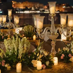 For this destination wedding in Udaipur, I designed an evening ceremony on the water's edge. The decor, featuring elegant candelabras and soft florals, was created to complement the romantic, historic city skyline.