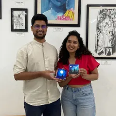 A couple with their miniature canvas paintings. The smiles say it all. It's about the shared experience as much as the art itself.
